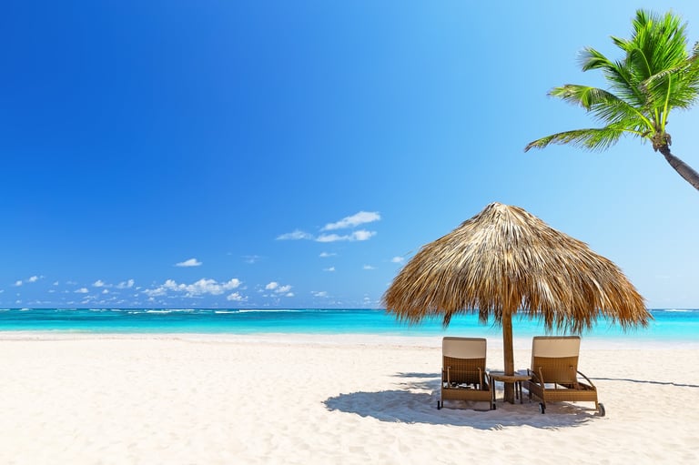 Two empty beach chairs on a summer sunny day at a tropical beach